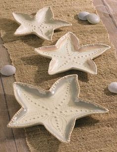 three ceramic starfishs sitting on top of sand