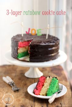 there is a cake that has been cut into pieces and sits on a table with the words, 3 - layer rainbow cookie cake