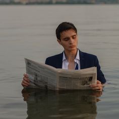 a man reading a newspaper in the water