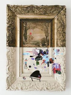 a painting is hanging on the wall next to a white frame with stickers all over it