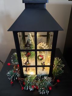 a lit up lantern with christmas decorations on it