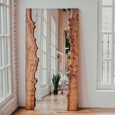 a large wooden mirror sitting on top of a hard wood floor