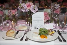 the table is set with flowers and silverware