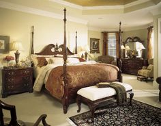 a large bed sitting in the middle of a bedroom next to a dresser and chair