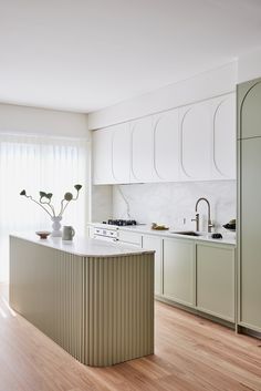 a kitchen with an island in the middle and two vases on top of it