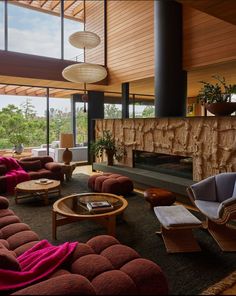 a living room filled with furniture and a fire place next to a large glass window