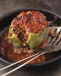 an eggplant stuffed with meat and sauce in a skillet