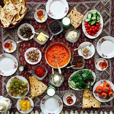 an overhead view of a table full of different foods and condiments on plates