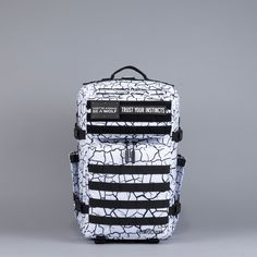 a white backpack with black and white stripes on the front, sitting against a gray background