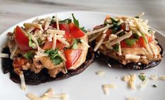 two stuffed mushrooms topped with cheese and tomatoes