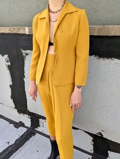 Vintage mustard yellow skirt and jacket suit. High waisted skirt with pleat in the front. Blazer jacekt with tie closures. Size 38. Measurements:  Skirt: Waist: 24" Length: 34" Hip: 37" Jacket: Shoulders: 28" Bust: 34" Length: 23.5" Sleeve length: 21" Yellow Fitted Blazer For Formal Occasions, Yellow Notch Lapel Suits For Work, Yellow Suit For Women, Elegant Yellow Suits For Spring, Spring Yellow Suits For Workwear, Yellow Long Sleeve Suits For Spring, Fitted Yellow Suits For Workwear, Spring Yellow Suits For Work, Spring Pleated Skirt Suit For Formal Occasions