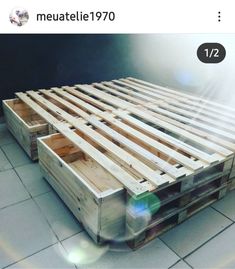 a bed made out of wooden pallets sitting on top of a tiled floor