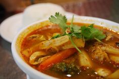 a white bowl filled with soup and vegetables