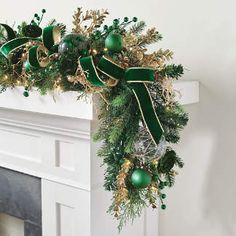 a decorated fireplace mantel with green and gold ornaments