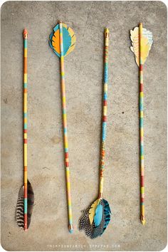 three different types of toothbrushes are lined up on the ground with feathers attached to them