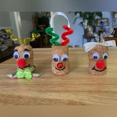 three toilet paper roll reindeers sitting on top of a wooden table next to each other