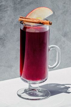 an apple and cinnamon drink in a glass mug