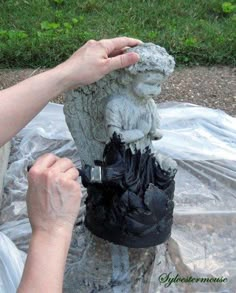 a person holding a camera near a statue