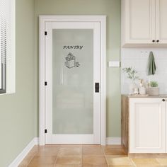 a kitchen with white cabinets and an open glass door that says privacy on the side