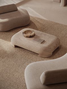 a living room with two chairs and a coffee table on the floor in front of it