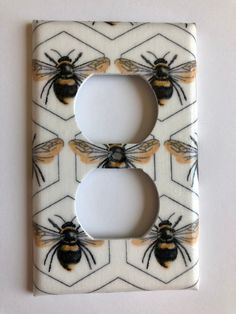 a light switch cover with bees painted on it's sides and the letter b