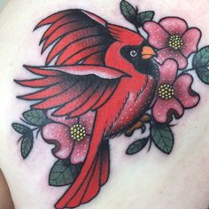 a red bird with flowers on it's back shoulder and chest is shown in this tattoo design