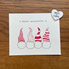 three gnomes with red and white hats on their heads are standing in front of a heart