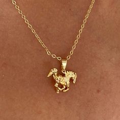 Si ce bébé n'est pas puissant, je ne sais pas ce qui l'est ! Avec son superbe pendentif en forme de cheval sur une chaîne délicate, ce collier ne manquera pas d'ajouter une touche de puissance à toutes les tenues que vous porterez. Associez-le à notre collier Serpent pour un ensemble emblématique ! Gold Horse Design Pendant Necklace, Gold Pendant Necklace With Horse Design, Horse Design Pendant Necklace As Gift, Horse Design Round Pendant Necklace As Gift, Horse Design Round Pendant Necklace For Gift, Round Pendant Necklace With Horse Design For Gift, Golden Birthday Gifts, Serpent Necklace, Chunky Gold Jewelry