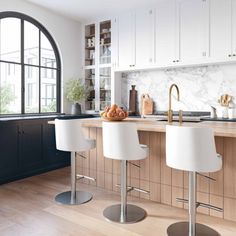 a kitchen with white stools and marble counter tops, along with an arched window