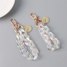 two pairs of earrings sitting on top of a table