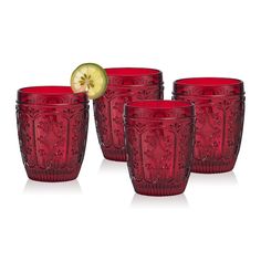 four red glass cups with an apple in the middle