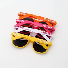 six pairs of sunglasses with different colored frames and sayings on them, all sitting side by side