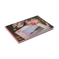 an open book with pink flowers on it