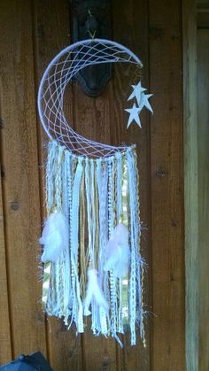 a white dream catcher hanging from the side of a wooden wall next to a door