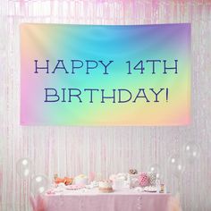 a birthday banner hanging over a table filled with cake