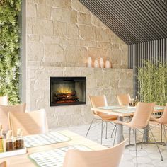 an outdoor dining area with tables, chairs and a fire place in the wall behind it