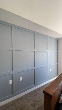 an empty room with blue painted walls and carpeted flooring in the foreground