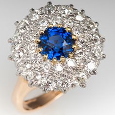 The ring is centered with one (1), prong set, round mixed cut natural sapphire set into a twelve-yellow gold prongs, and surrounded by 18K white gold double halo setting accented with twenty-eight (28), prong set, old European cut diamonds. The ring is finished with a reverse tapered 14K yellow gold shank. The ring measures 15.2mm at the top, rises 6.1mm above the finger, tapering to 2.1mm wide and 0.9mm thick at the base of the shank. This ring is currently a size 5 and we offer complimentary r Yellow Gold Sapphire Cluster Ring With Brilliant Cut, Yellow Gold Cluster Sapphire Ring With Brilliant Cut, Dazzling Yellow Gold Sapphire Ring With Brilliant Cut, Cluster Yellow Gold Sapphire Ring, Cluster Sapphire Ring In Yellow Gold, Yellow Gold Sapphire Cluster Ring, Yellow Gold Cluster Sapphire Ring, Yellow Gold Sapphire Cluster Ring With Center Stone, Yellow Gold Cluster Sapphire Ring With Center Stone