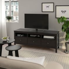 a flat screen tv sitting on top of a wooden entertainment center in a living room