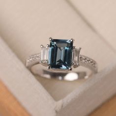 This ring features a 7*9mm emerald cut London blue topaz and sterling silver finished with rhodium. Customization is available. It is made by hand, and it will take about 7 days to finish the ring after your payment is completed. Main stone: London blue topaz Main stone weight: Approx 3.3 ct Metal type: sterling silver finished with rhodium Accent stone: cz Customization is available, I also can make it with 14k solid gold (white or yellow or rose) and diamond accent stone, just feel free to con Elegant Emerald-cut Topaz Rings, Elegant Topaz Rings With Rectangular Stone, Emerald Cut Topaz Ring In 14k White Gold, Elegant Baguette Cut Topaz Promise Ring, Emerald Cut Sapphire Ring With Baguette Diamonds, Elegant Octagon Topaz Ring With Center Stone, Elegant Octagon Topaz Ring For Wedding, Classic Emerald-cut Topaz Ring In Sterling Silver, Elegant Topaz Ring With Baguette Cut