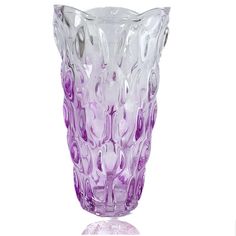 a purple glass vase sitting on top of a white table