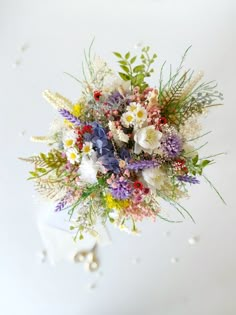 a bunch of flowers that are sitting on a white table top with water droplets around them