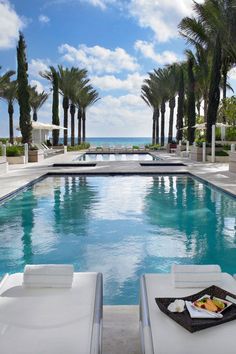 an empty swimming pool surrounded by palm trees