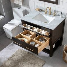 a bathroom with a sink, toilet and drawers in the middle of the floor area