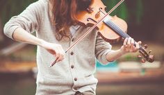 a man with long hair playing the violin