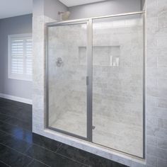 a bathroom with a walk in shower next to a window