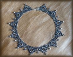 a beaded bracelet with silver beads on a wooden surface in the shape of a star