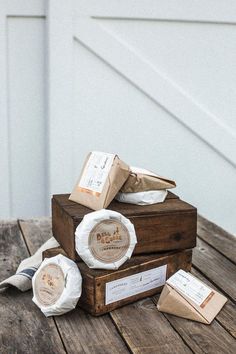 three pieces of cheese sitting on top of a wooden table next to some bags and papers