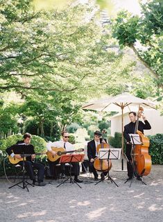 a group of men playing instruments under an umbrella