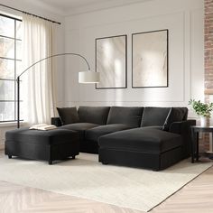 a living room with a large sectional couch and two framed pictures on the wall above it